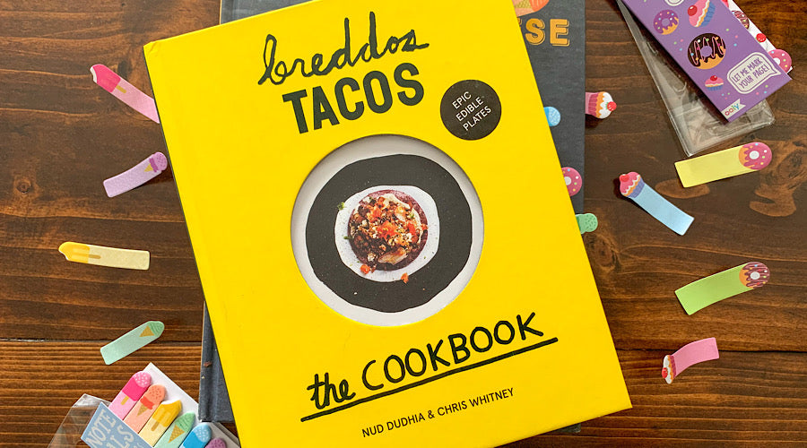 cook book with fun tabs in it on wooden surface