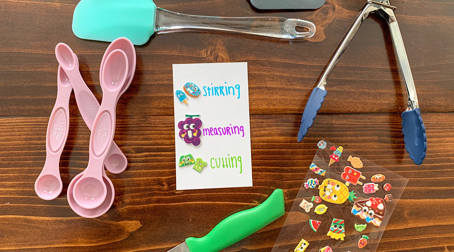 cooking utensils, index card and food stickers on wooden surface