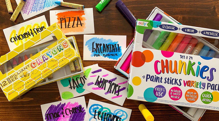 chunkies paint sticks, crayons and colorful index cards on wooden surface