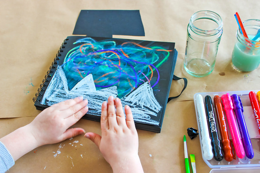 Cam pasting down the mountain outline she cut out and added snowy details.