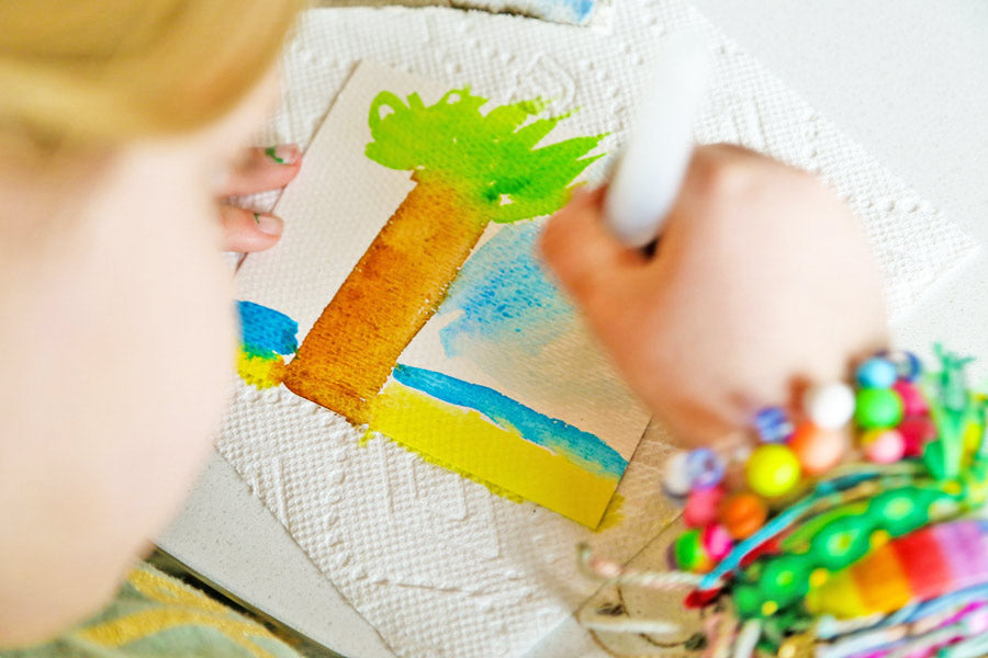 Girl watercoloring a tree with a water brush