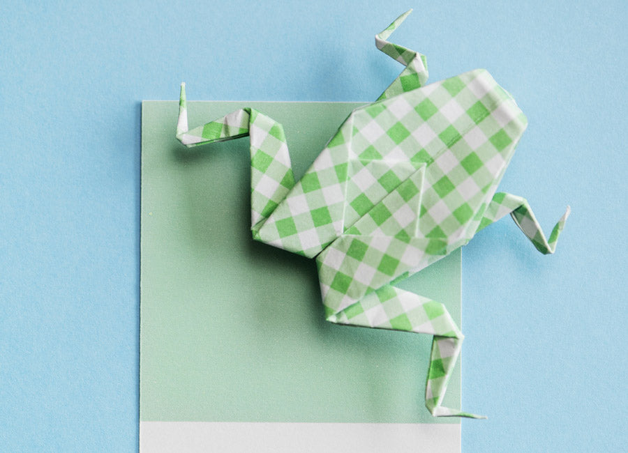 Origami frog made out of green and white paper