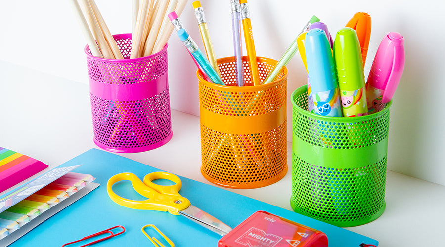 pink, orange and green pencil holders with school supplies in and around them