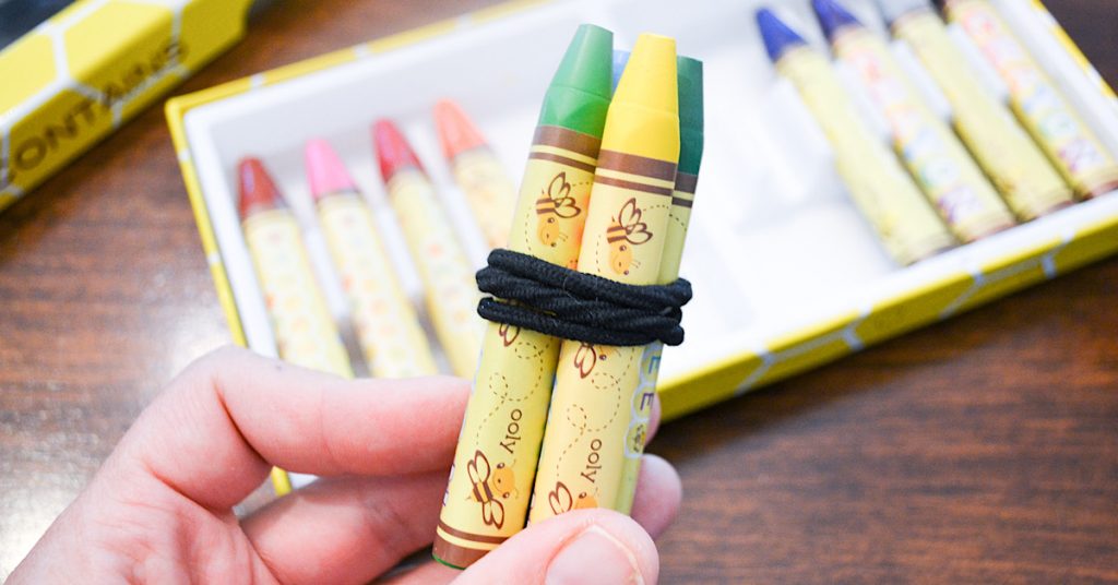crayons in a bundle with a black hair tie