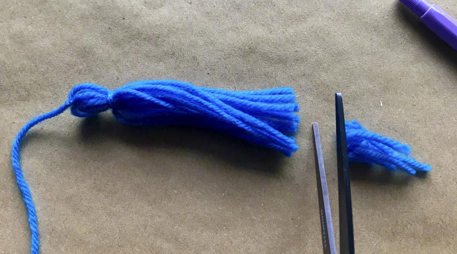scissors trimming blue yarn