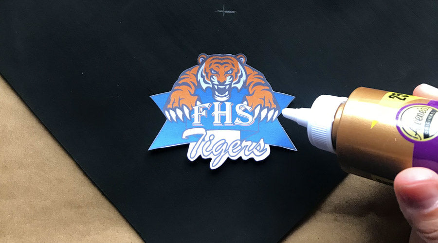 graduation cap with hand gluing on high school logo