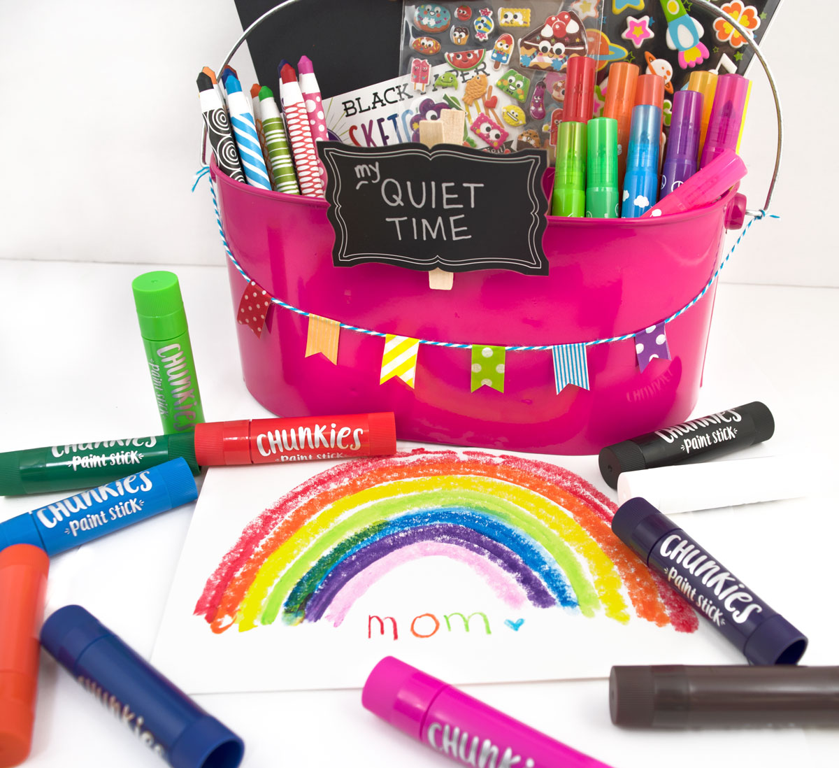 Kids art supply basket with crayons, markers, paint sticks, stickers and a card for mother's day.