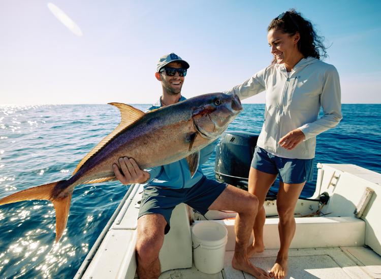 Man holding a fish while saltwater fishing