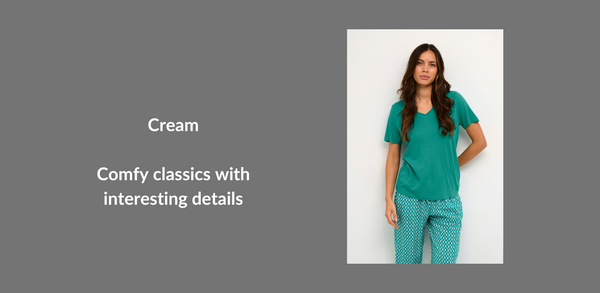 A woman wears an emerald green t-shirt with a v-neck. Text reads: Comfy classics with interesting details