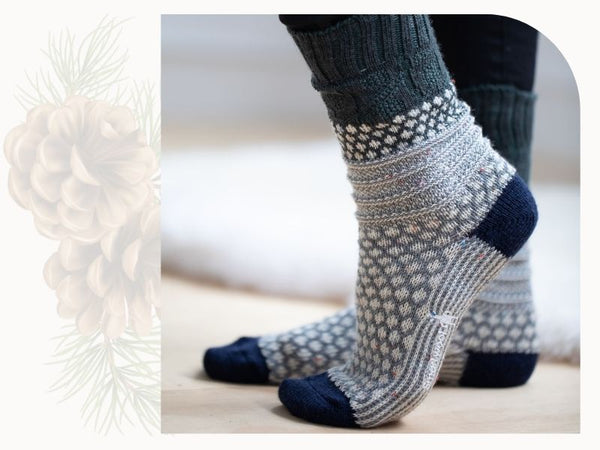 A person wears a pair of socks. They have a white "popcorn" pattern and dark blue heels and toes.