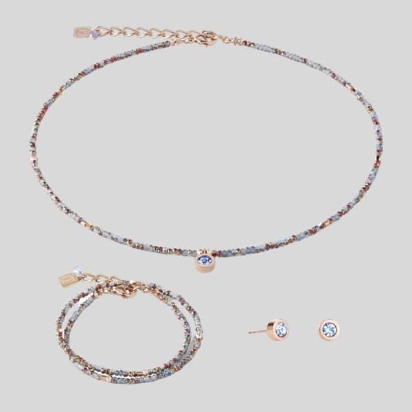 A delicate necklace, bracelet and earrings are shown.