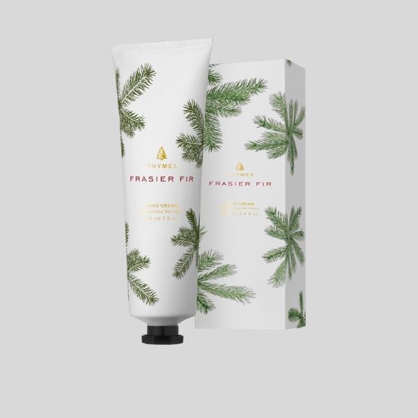 A tube of Frasier Fir hand cream is shown in front of its box, which features green fir needles.,