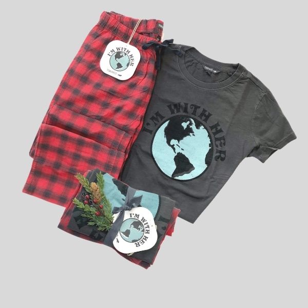 A pair of pyjamas is shown. The T-shirt reads: "I'm With Her" and shows a picture of the globe. The pants are red and black checked.