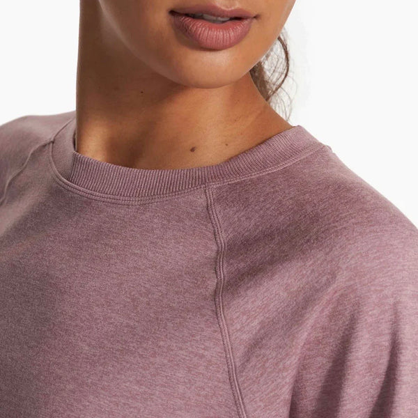 A woman's shoulder and chin are shown. She is wearing an activewear top in a mauve colour.