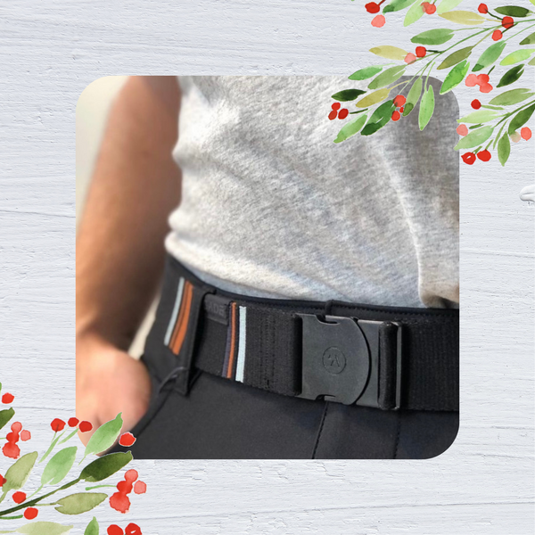 A man's waist is shown. He wears a nylon belt with a black background and an orange and white striped pattern. the belt has a black plastic buckle.