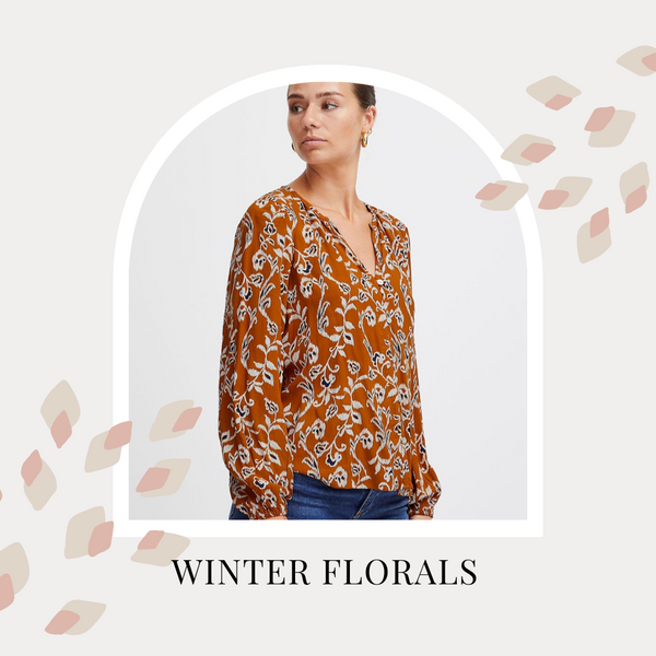 A woman wears a floral printed blouse with long sleeves. Text reads: Winter florals