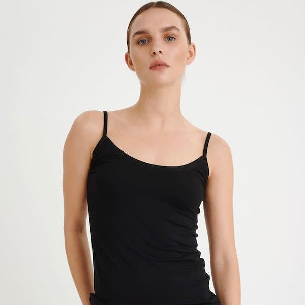 A woman wears a black camisole.