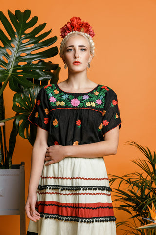 Model in Frida Kahlo costume dress wears Katmeleon Jewellery monstera drop earrings and Frida Kahlo pendant necklace