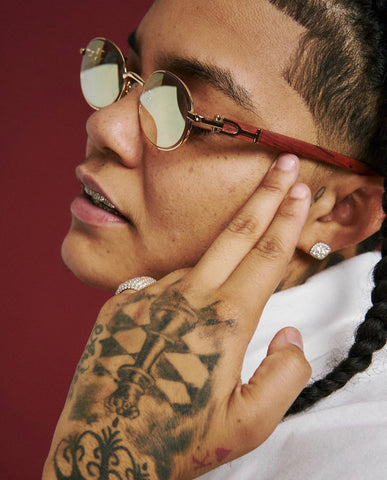 Rapper Young M.A wears Cartier style cherry wood oval sunglasses with mirrored lenses by Vintage Wood Collection