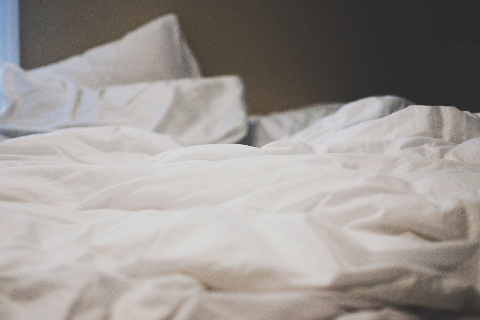 A bed with pillows and white sheets.