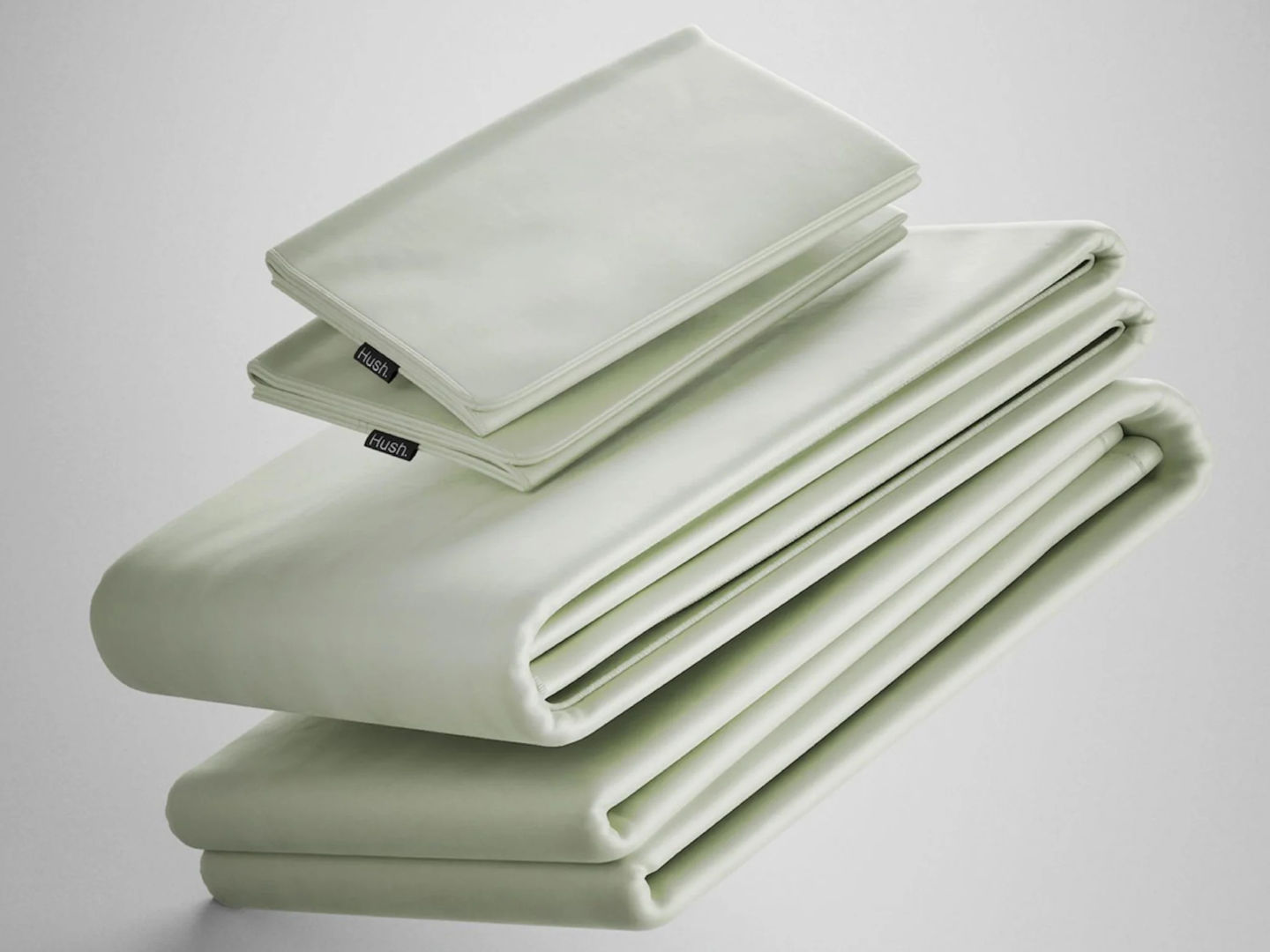 A neatly folded set of Hush Iced Bamboo Cooling Sheets and Pillowcase in Sage color.