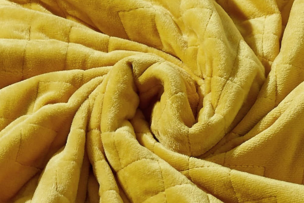 A close-up shot of Gravity Weighted Blanket in gold color.