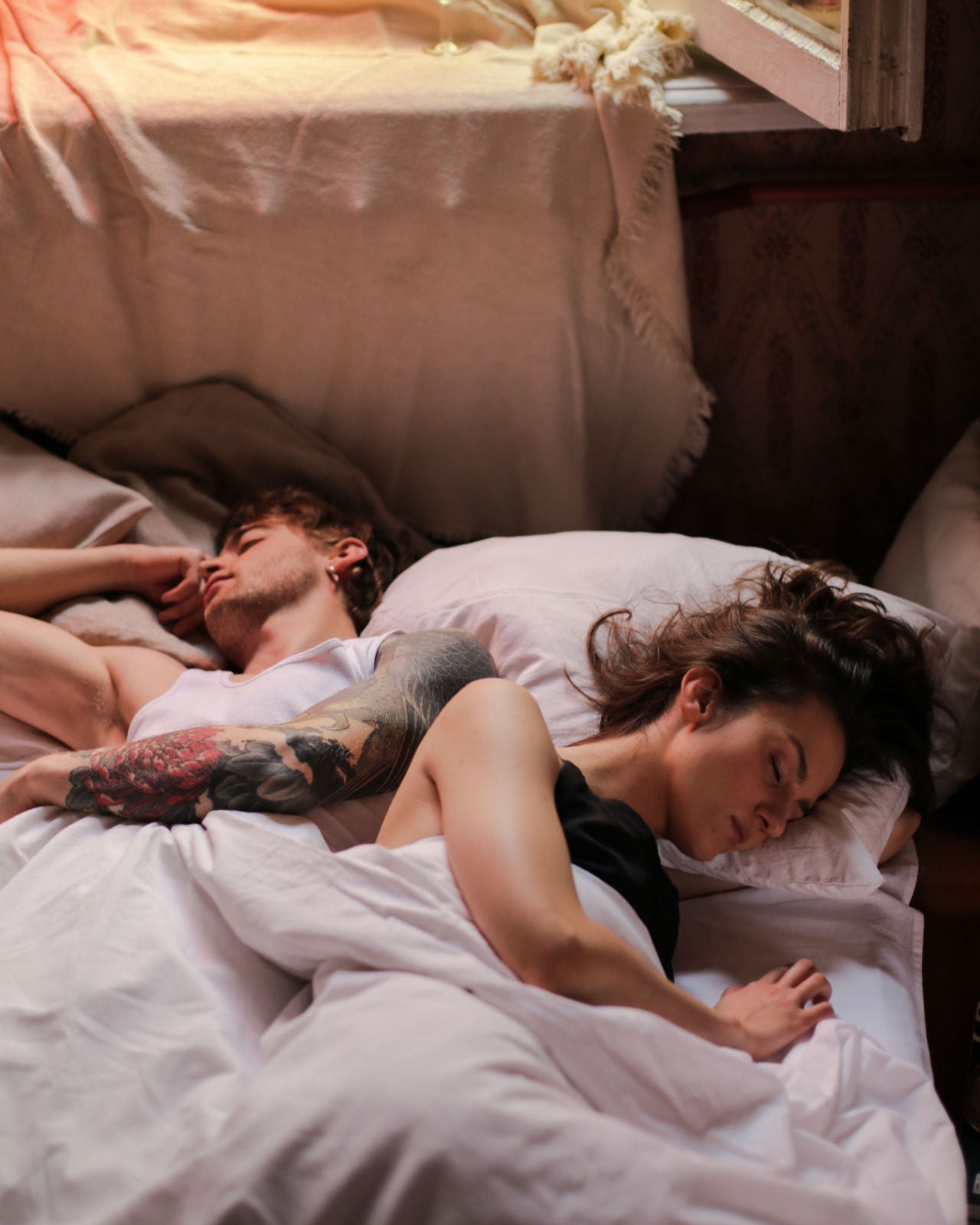 couple sleeping on bed with white blanket