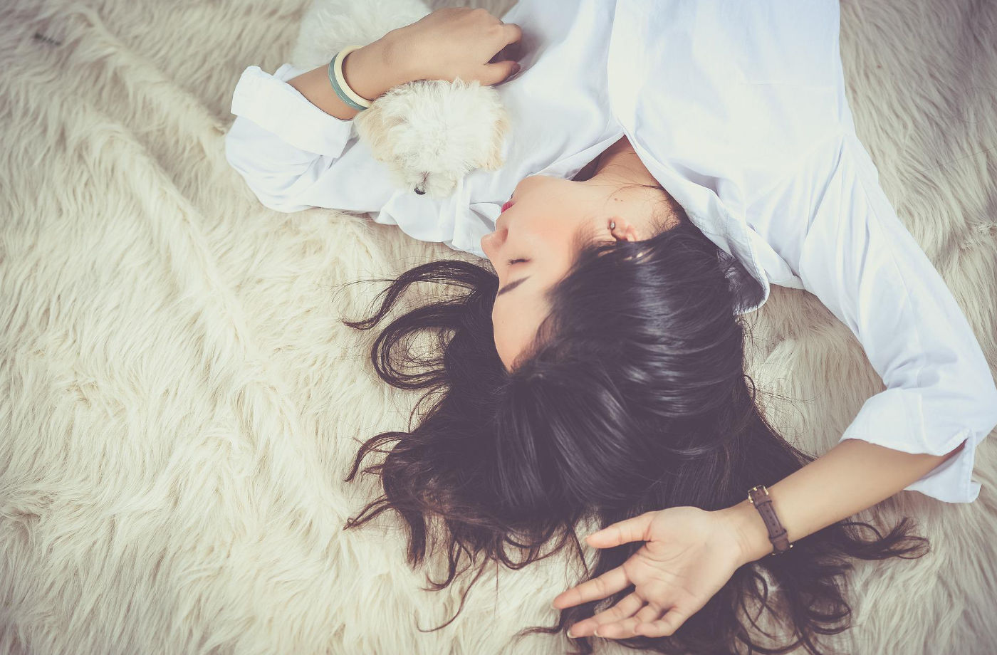 sleeping woman on bed cuddling with a dog