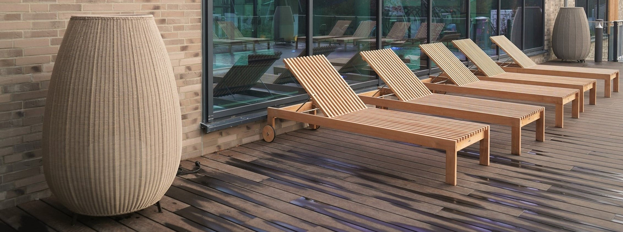 Five Cane-line Amaze sunbeds in teak wood on the terrace