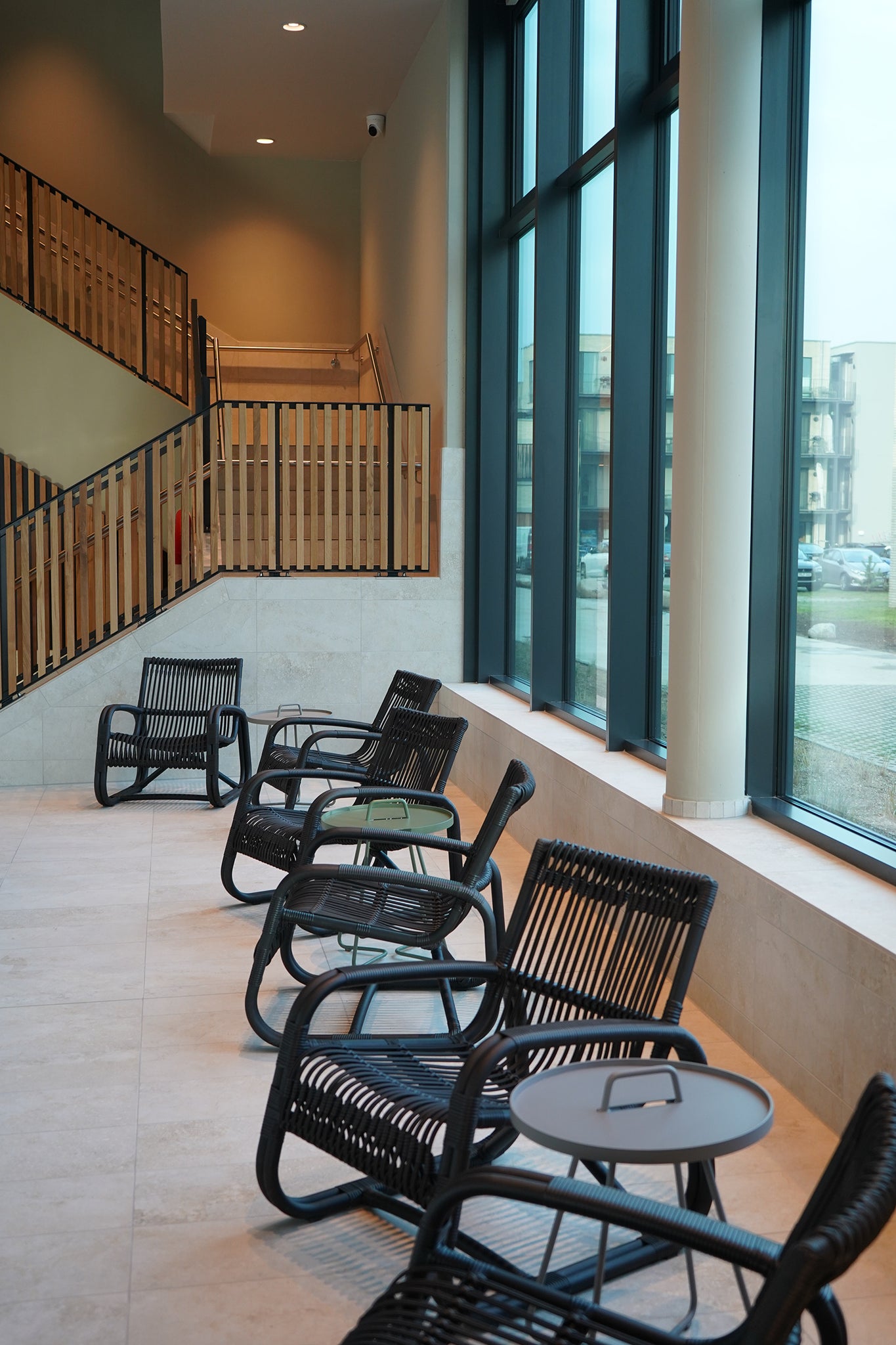 Five black Cane-line Curve lounge chairs at Marissa Ferienpark indoor spa area with grey and green side tables