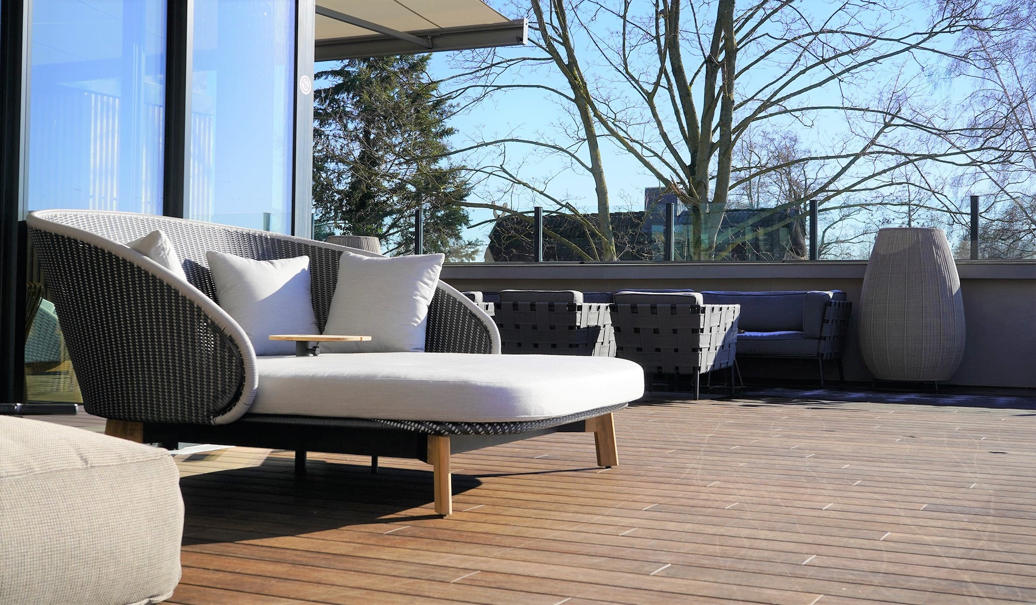 Cane-line Peacock outdoor daybed with black and grey colours, grey cushios, midldle sidetable in teak natural