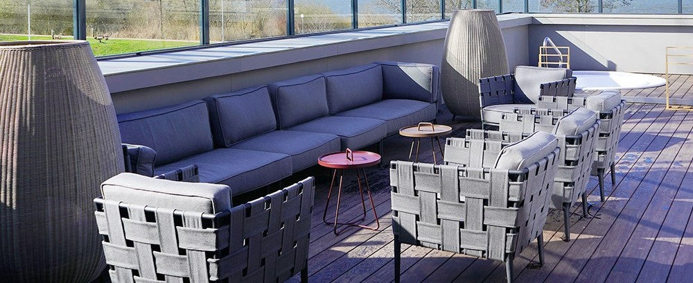 Outdoor grey lounge modular sofa with red small coffee table on the terrace of Marissa Ferienpark
