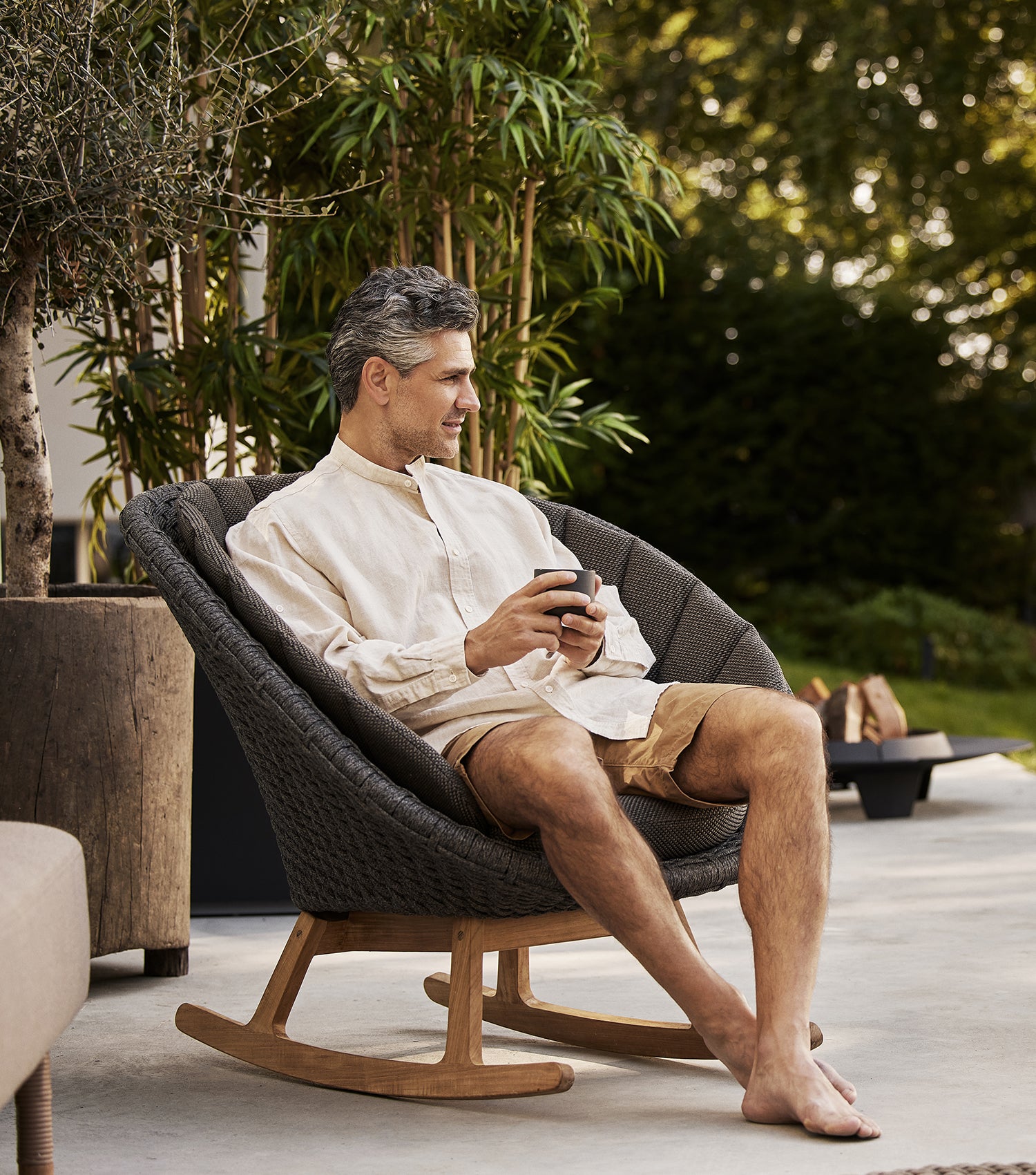 Peacock rocking chair with man drinking coffee