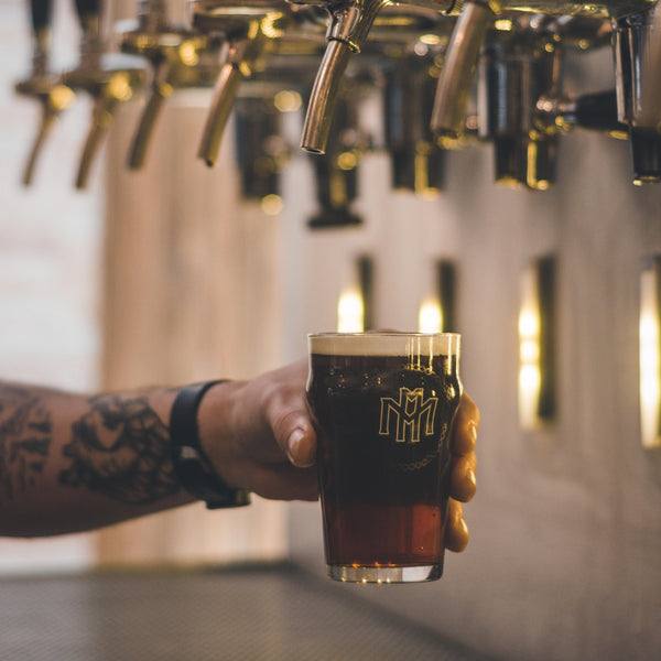 man pouring beer out of draught tap