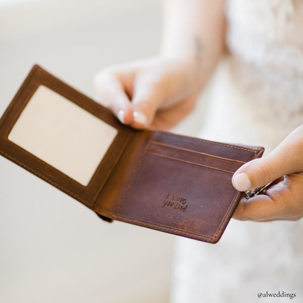 engraved leather wallet held by a bride 