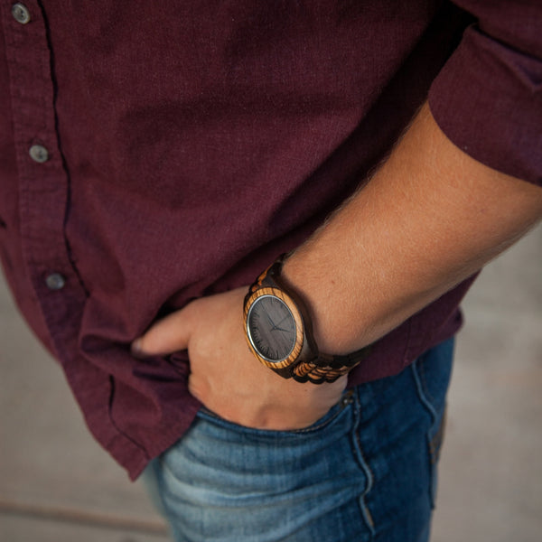 wooden watch on a wrist with a maroon shirt