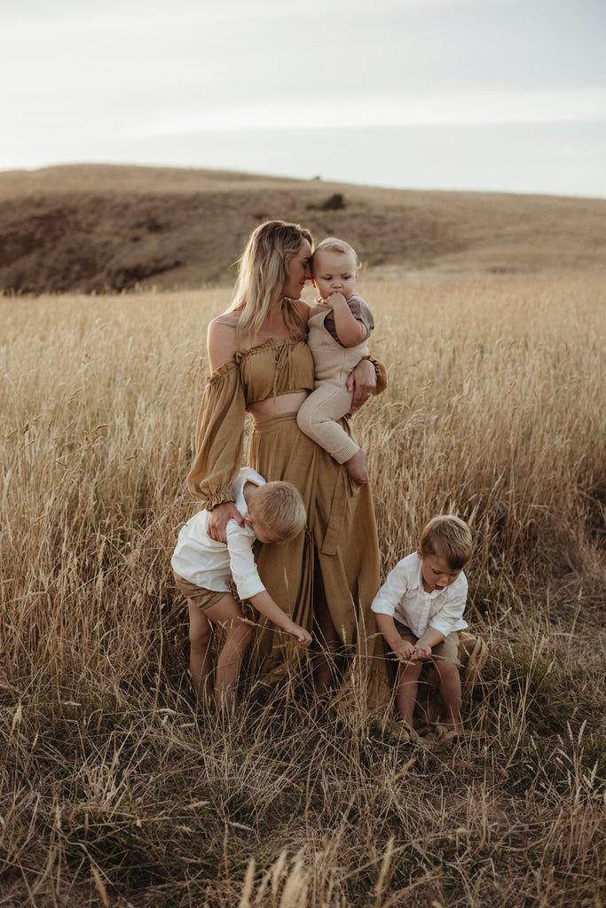 A beautiful non-pregnant lady wears Mama Rentals Reclamation 'Dreams Like These' three piece gown in Mustard colour at her family shoot.