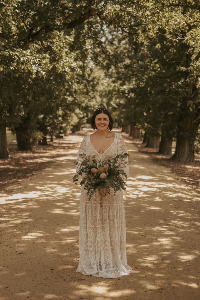 A beautiful non-pregnant lady wears Mama Rentals Reclamation Be Love gown in Nude Ivory at her wedding ceremony.