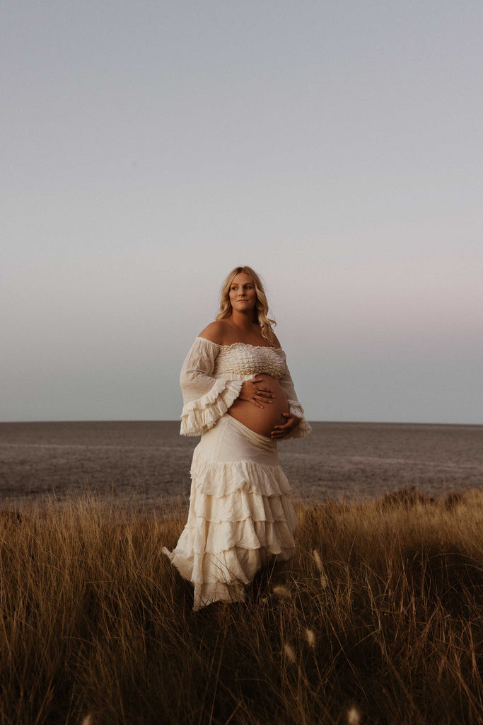 A beautiful pregnant lady wears Mama Rentals' The Boho Shed 'Wild Heart' Two Piece Set at her maternity session.