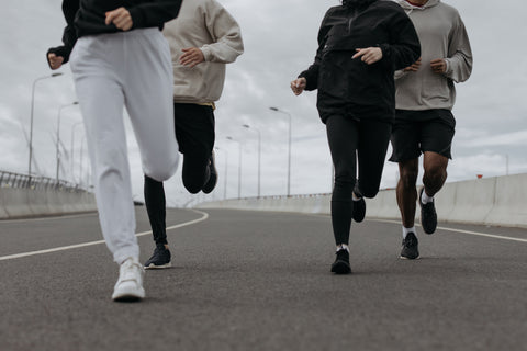 Four people jogging on a track as part of a directive to exercise regularly as a natural solution to fatigue. 