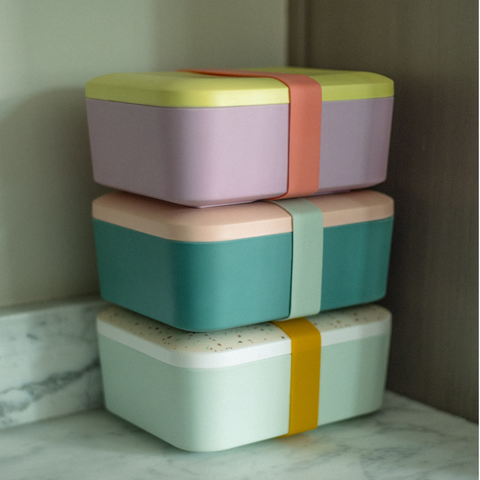 3 Bento box lunch boxes with secure band stacked on top of each other