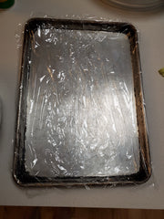 Plastic wrap lined baking sheet