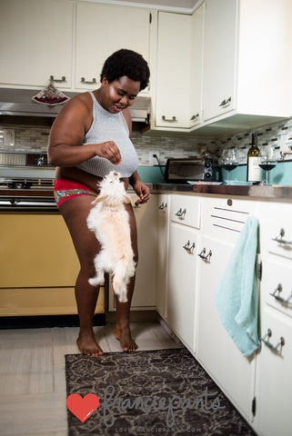 Woman playing with dog in kitchen