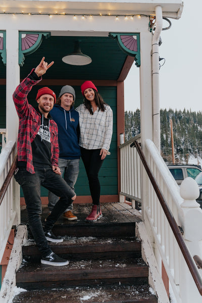 Photo of the three owners smiling standing in front of Truckee coffeeshop: Nick, Brad & Laura