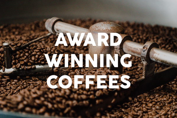 Award winning coffees text overlaid over coffee roasting photo