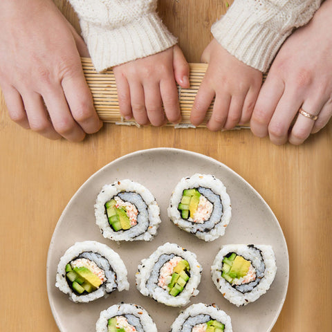 Kids making sushi with parents
