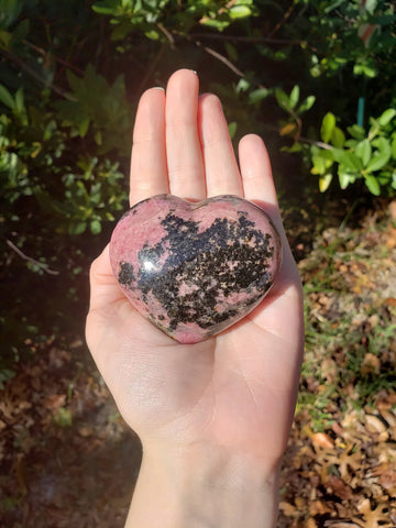 Hand holding puffy rhodonite heart