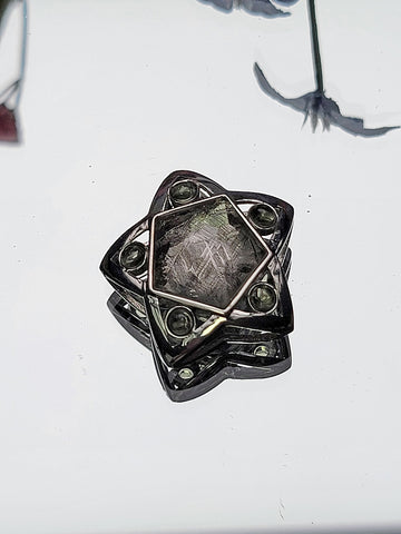 Iron meteorite and moldavite sterling silver pendant shaped like a star.