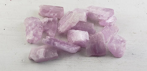 Image of raw, purple kunzite spudoemene specimens against a plain background