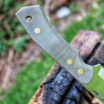 Close up, on the handle of a handmade bushcraft knife. Made in Denmark by the young talented knifemaker Mikkel Hvedegaard. Handle is made in Hunters Green Canvas Micarta, with brass corby screws